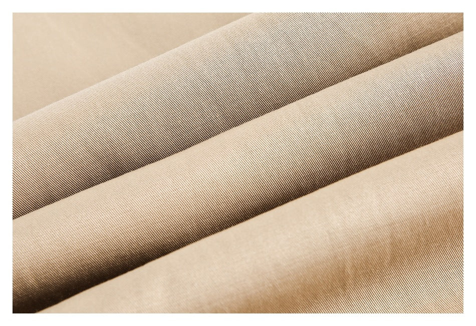 Close-up of beige trouser fabric folded to show its fine diagonal weave.