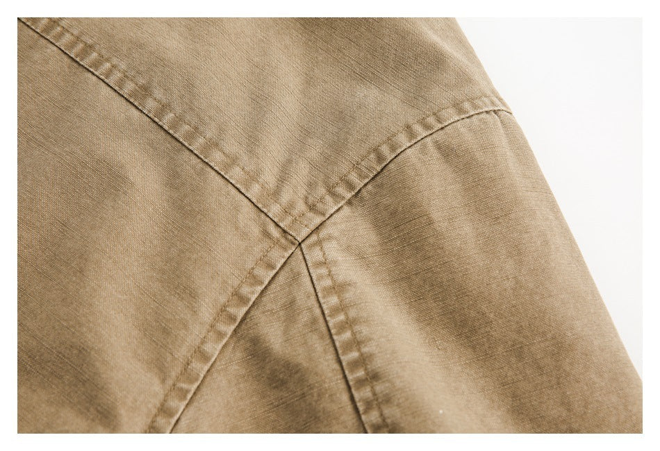 Close-up of intersecting stitched seams on tan garment fabric.