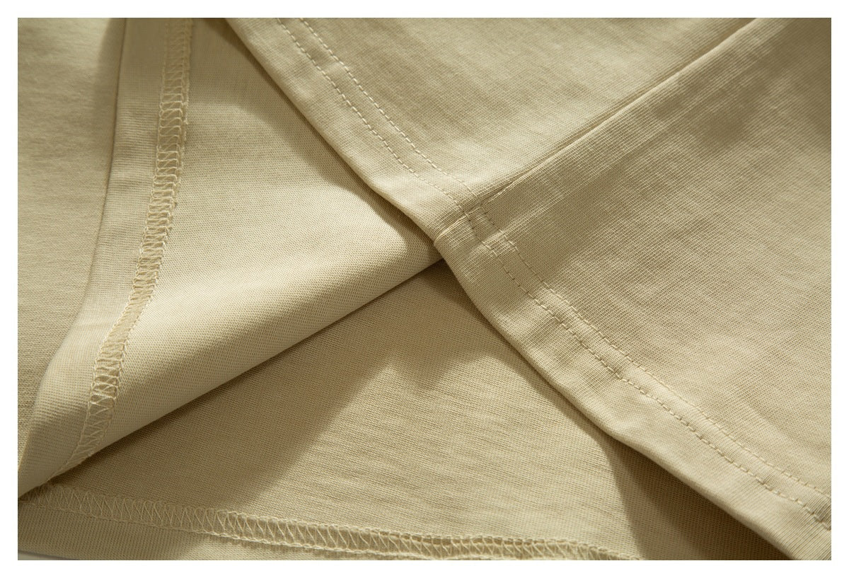Inside view of a light beige garment showing overlocked seams and hem stitching.