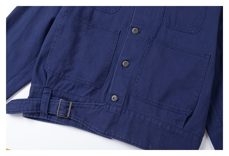 Close-up of a navy work jacket front with large patch pockets, star-pattern buttons, and an adjustable waist tab.