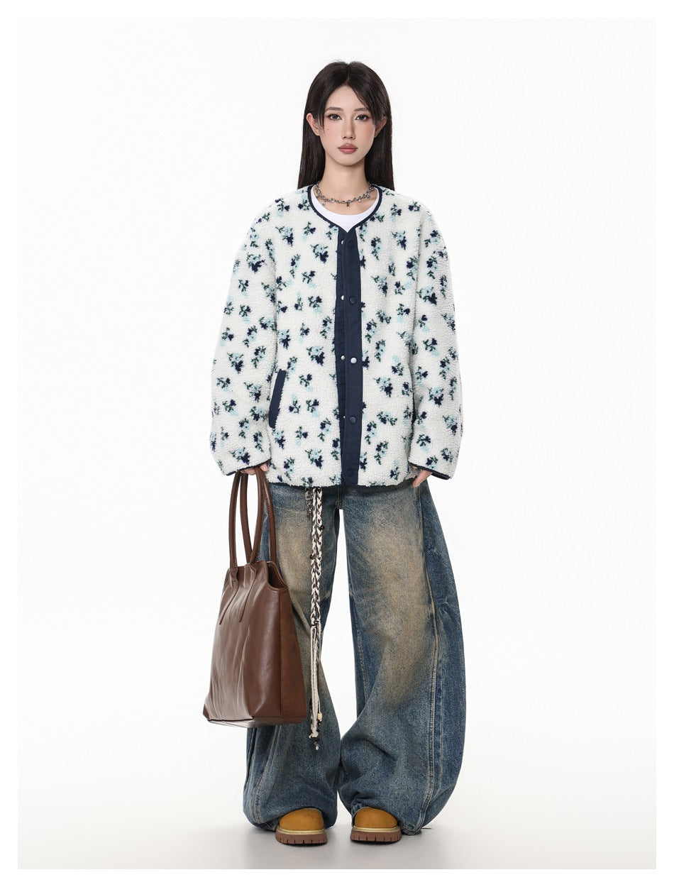 Full-length model wearing a white floral fleece jacket with navy trim and loose jeans, carrying a brown tote.