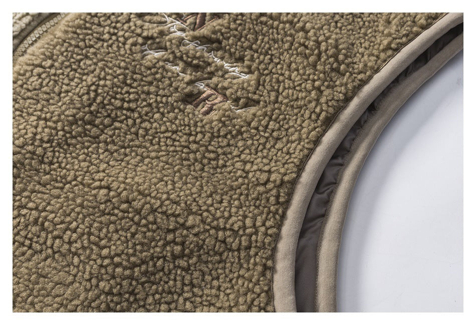 Close-up of taupe-brown looped fleece with curved gray-beige binding and a small stitched detail.