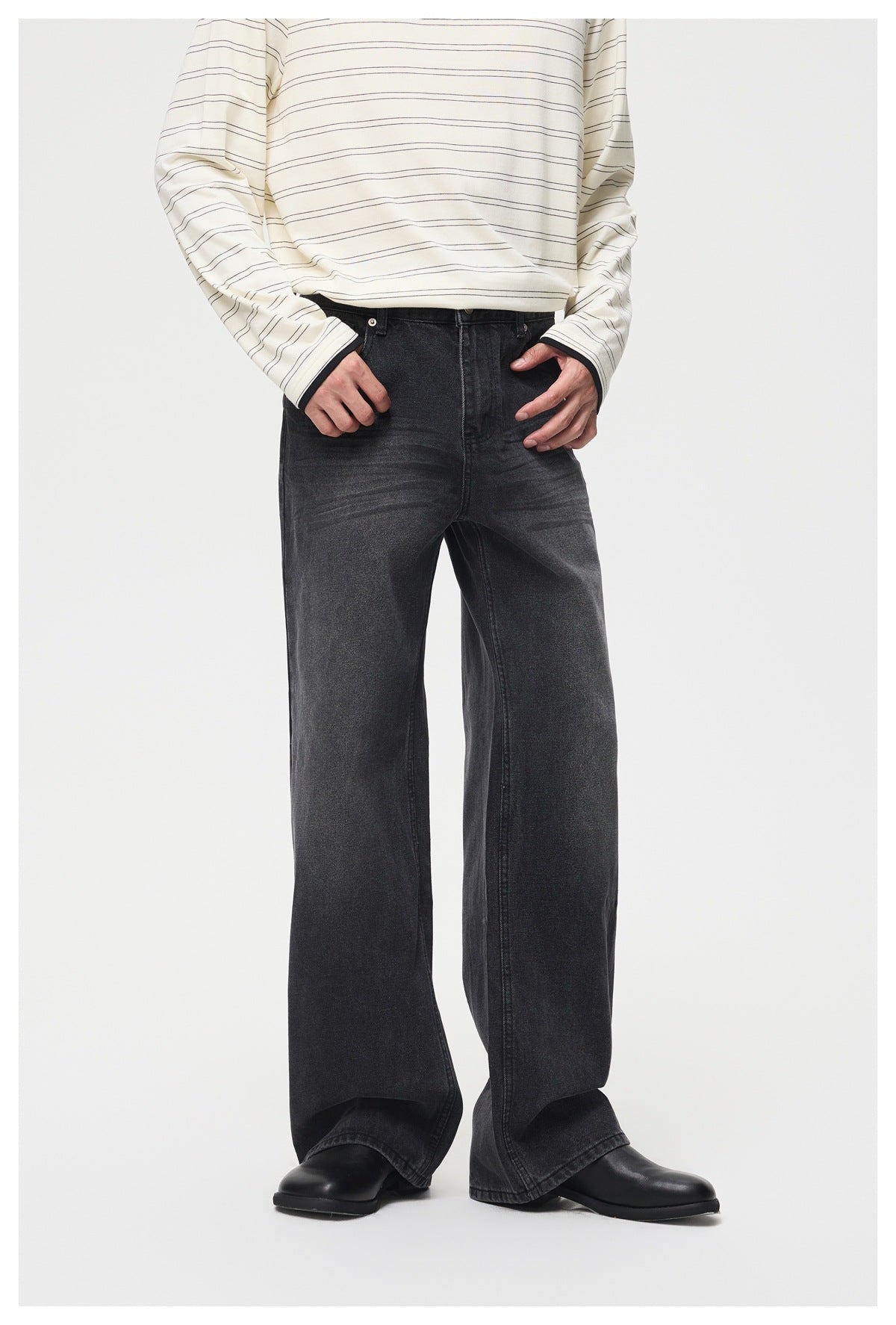 Model wearing black washed wide-leg jeans with a striped cream long-sleeve top and black boots, front view