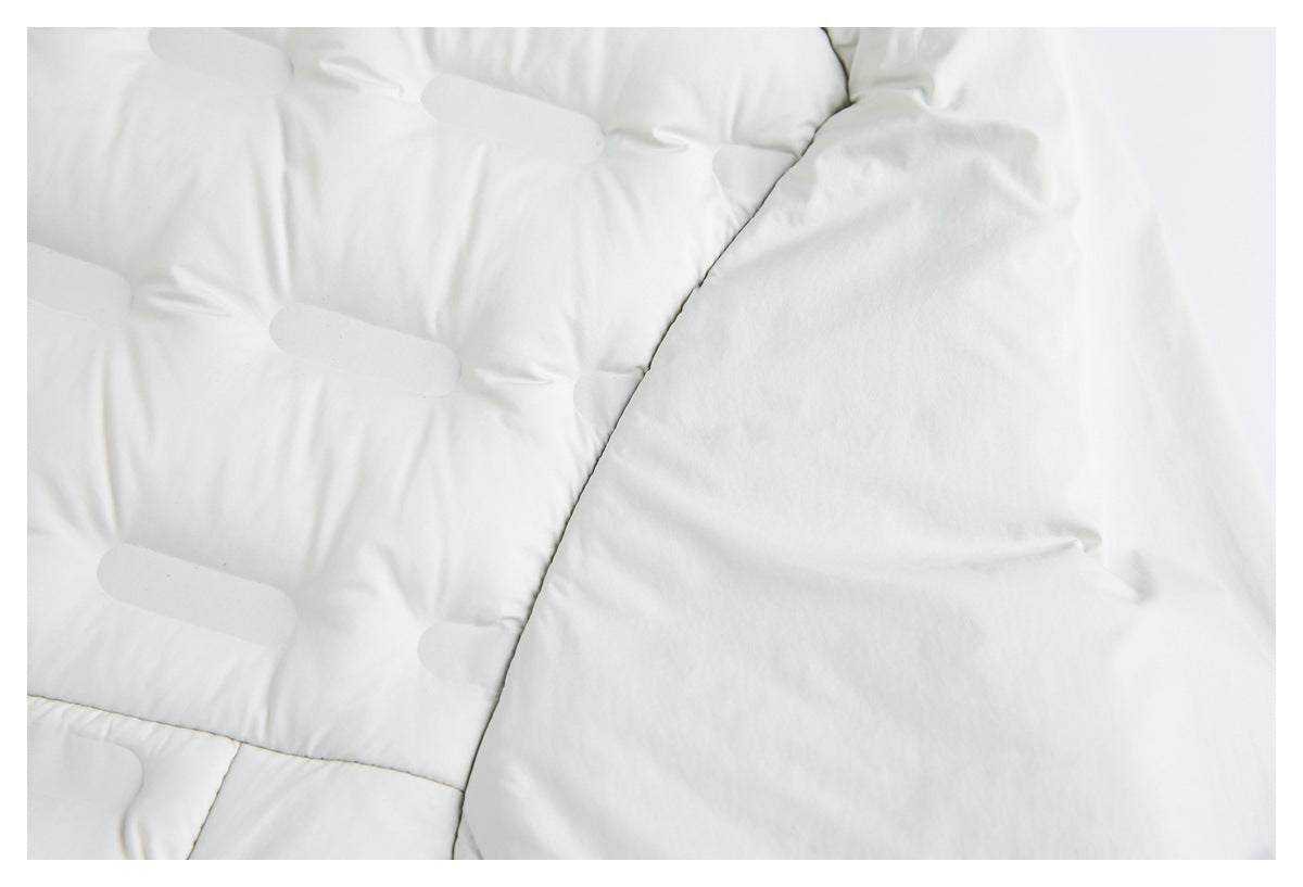 Close-up of white padded jacket panels with curved stitching and subtle elongated accents.