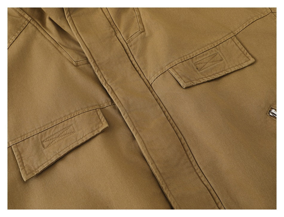 Close-up of the tan jacket's chest flap pockets and front placket.