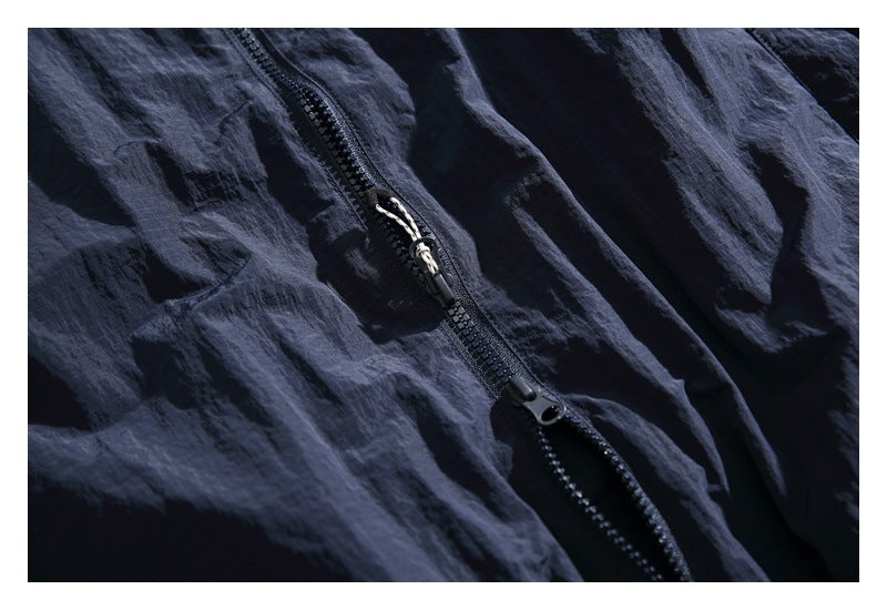Close-up of a dark navy jacket's front zipper and textured fabric.
