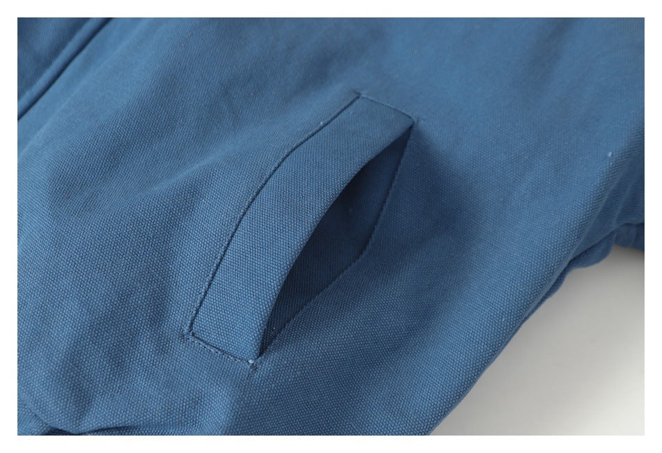 Close-up of a slanted pocket opening on the blue jacket.