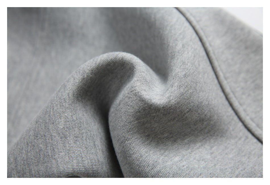 Macro view of the gray knit fabric and seam of the sweatpants.