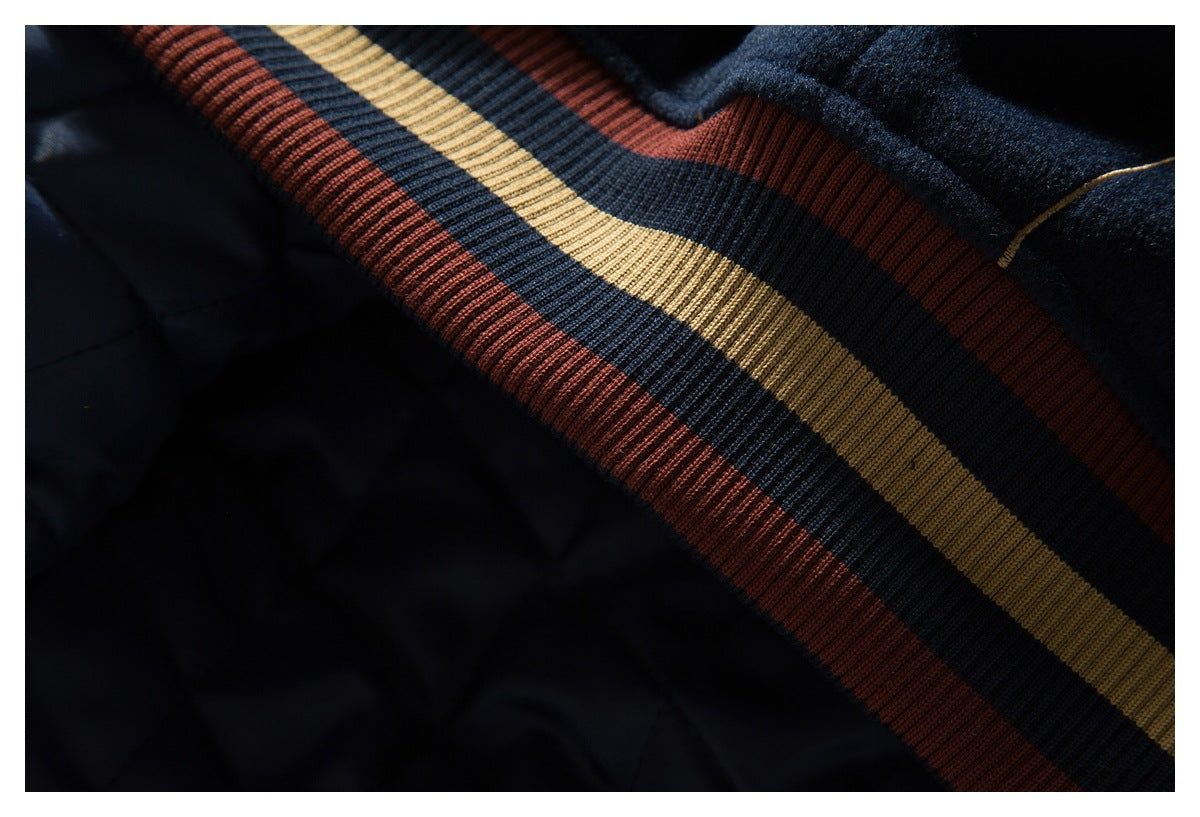 Close-up of rust, navy, and tan striped ribbing on a navy jacket.