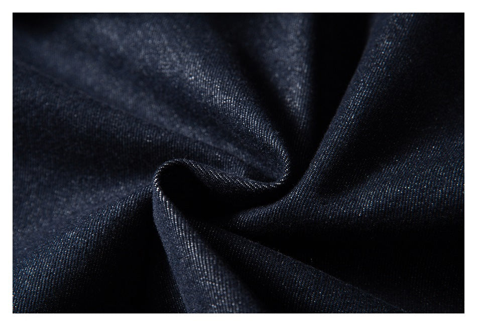 Close-up of dark indigo denim fabric arranged in soft folds.