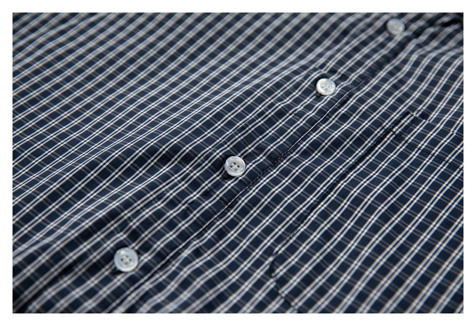 Close-up of the navy plaid shirt front, showing the button placket and white buttons.