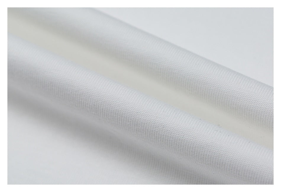 Close-up of white fabric folded to show its fine knit texture.