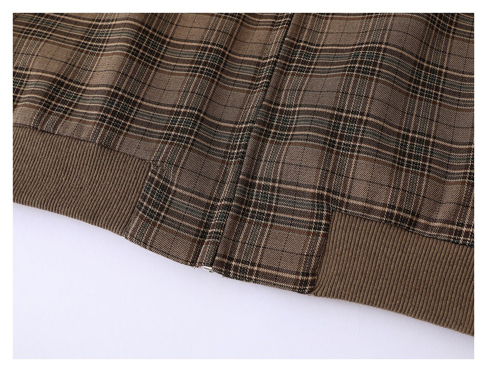 Close-up of the brown plaid jacket's ribbed hem and lower zipper.