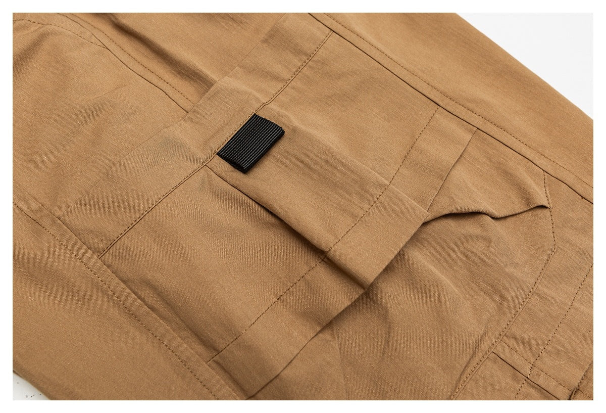 Close-up of a tan cargo pocket with a small black fabric tab.