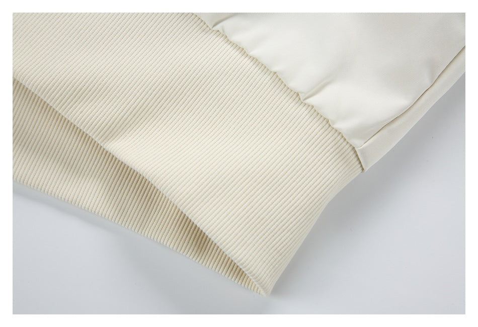 Close-up of a wide cream ribbed cuff attached to a white sleeve.