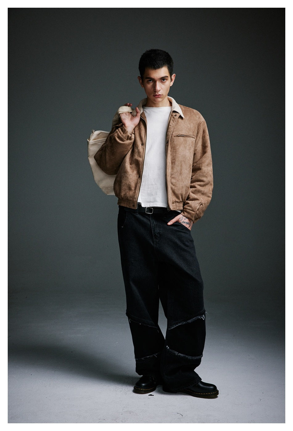Full-length model wearing a tan jacket with a cream collar, white tee, and loose black jeans.
