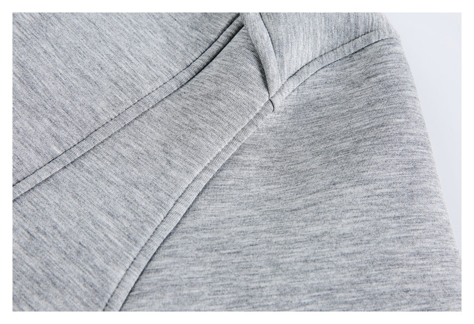 Close-up of heather gray knit fabric with intersecting curved seams.