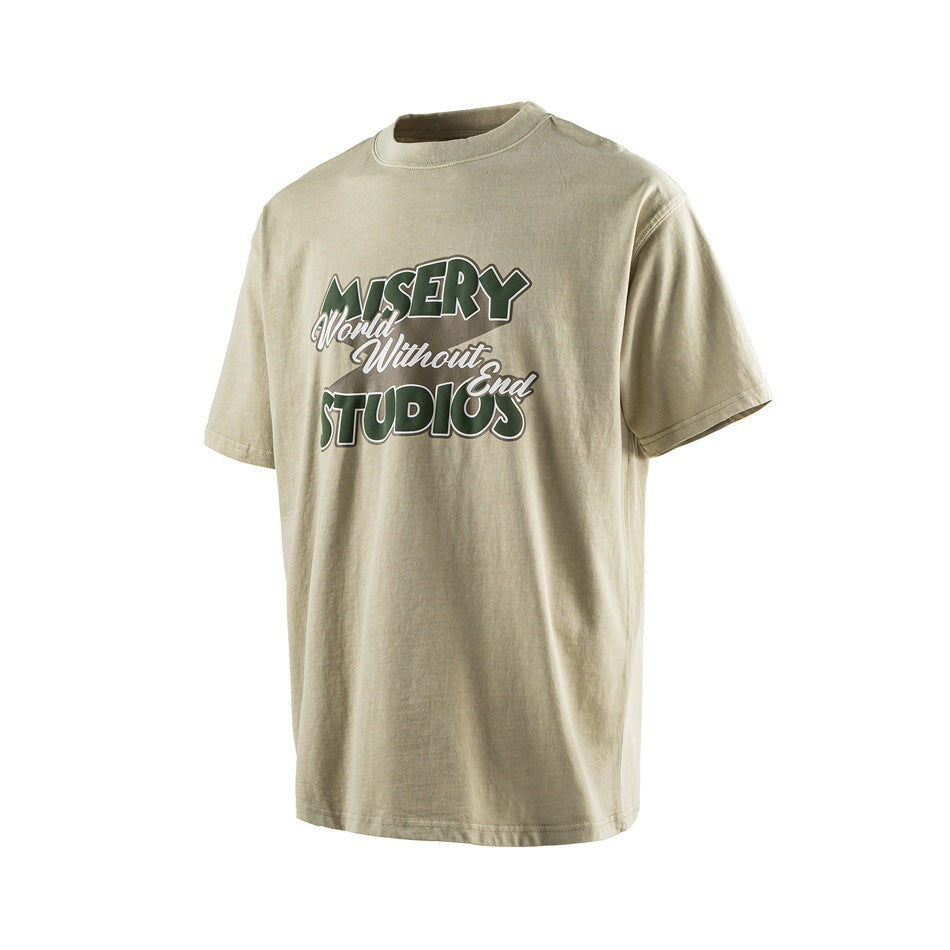 Khaki short-sleeve T-shirt with green 'MISERY World Without End STUDIOS' graphic, angled three-quarter front view