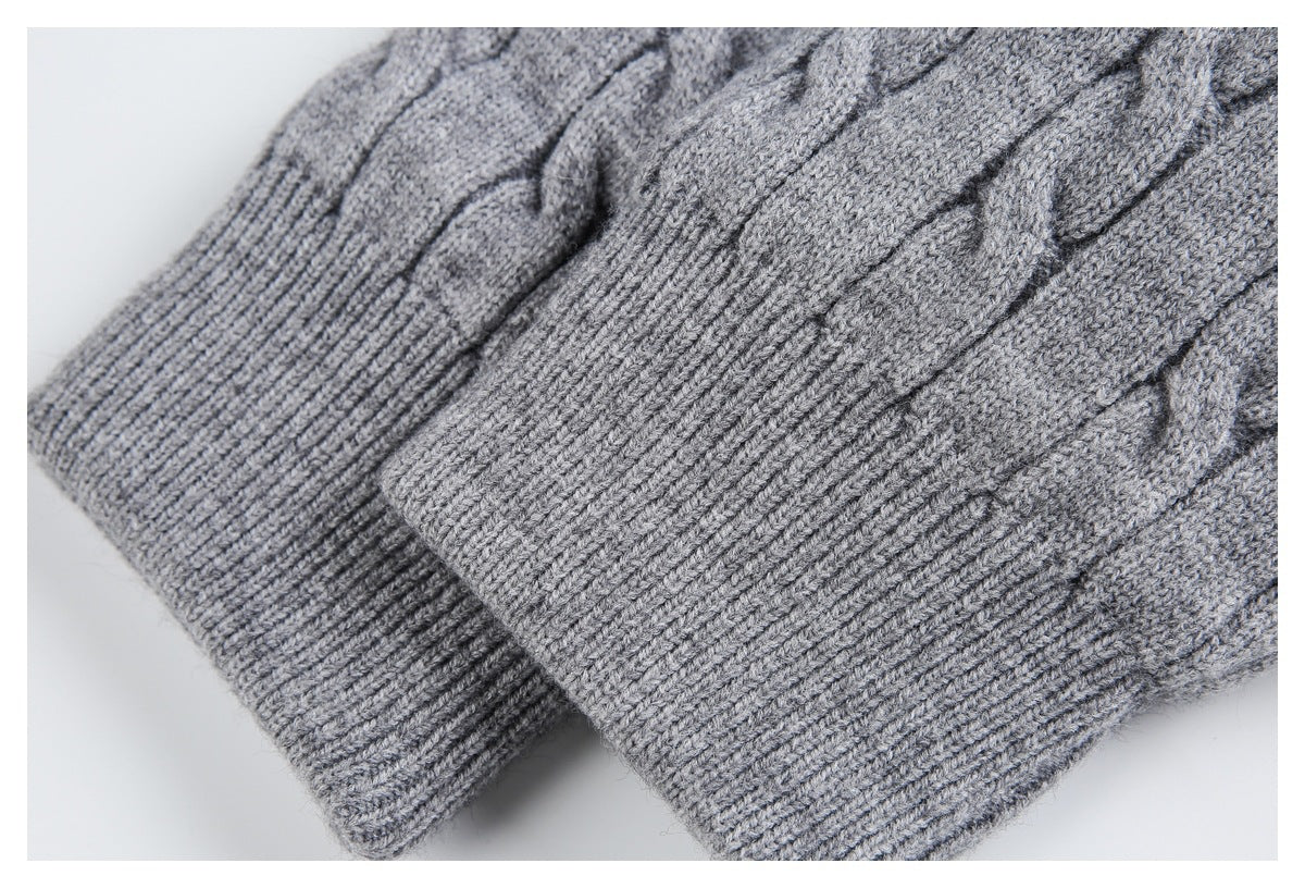 Close-up of overlapping ribbed cuffs and cable-knit fabric on a gray sweater.