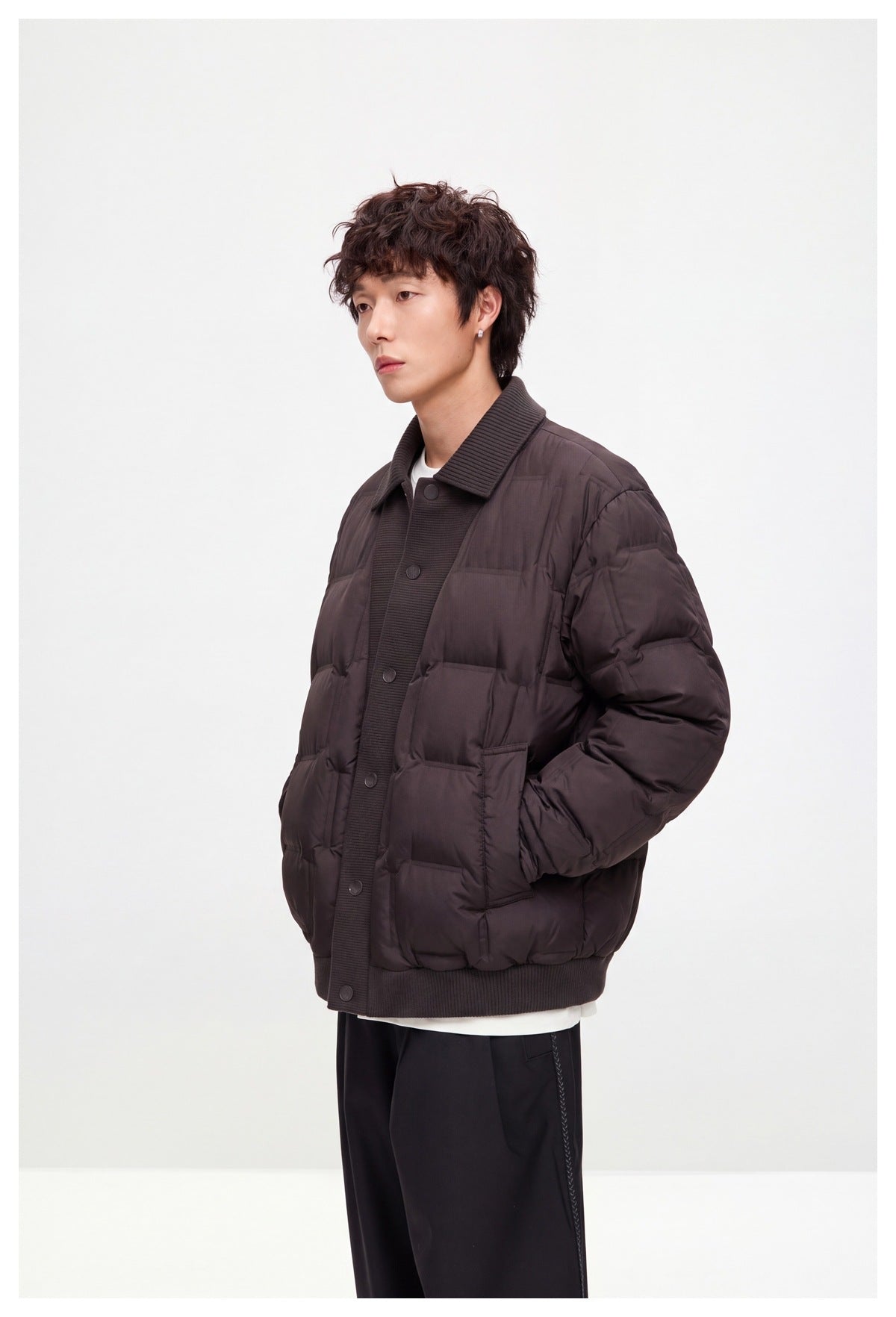 Model wearing a dark plum quilted button-front jacket with a ribbed collar, cuffs and hem, shown at an angle.