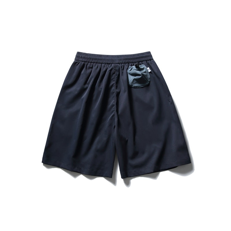 Navy shorts with an elastic waistband and a small matching pouch attached near the waist.