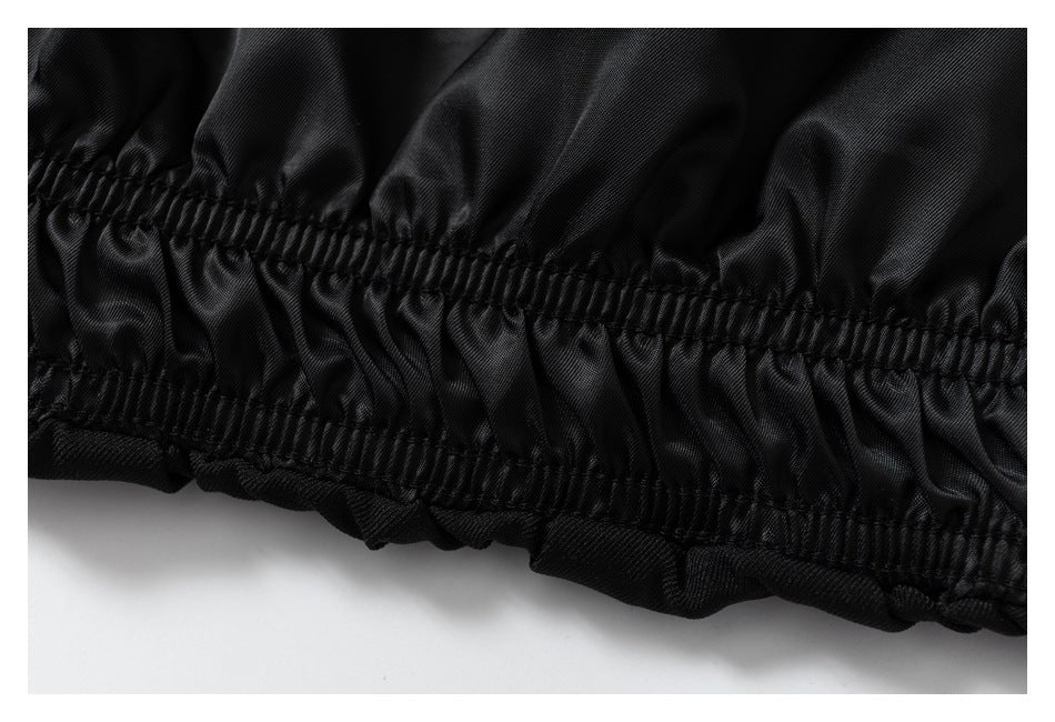 Close-up of a gathered elastic seam along the edge of a black garment.