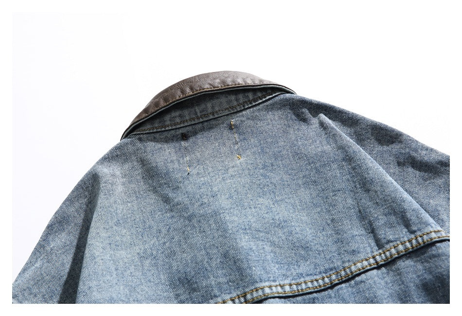 Close-up of a blue denim jacket's back yoke and brown collar against a white background.