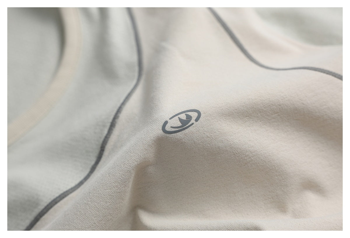 Close-up of a small gray emblem printed on light beige fabric beside a curved seam.