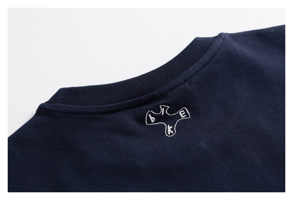Back neckline of a dark navy shirt with a small white embroidered outline emblem.