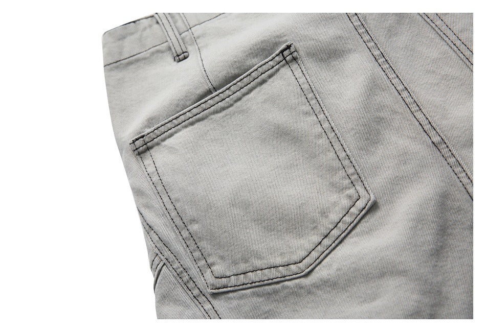 Close-up of a light gray denim pocket with dark stitching and a belt loop.