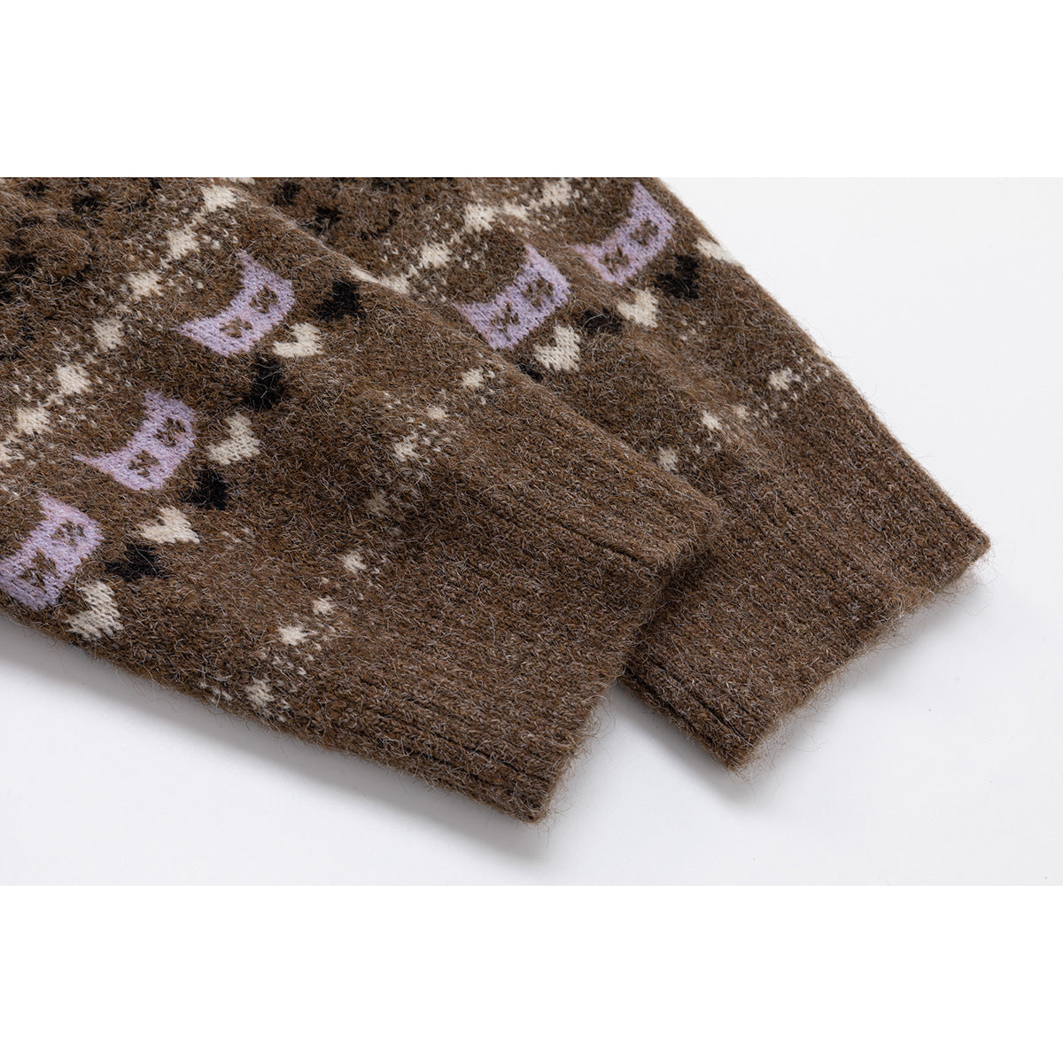Close-up of the brown cardigan's ribbed sleeve cuff and cream and lilac cat motifs.
