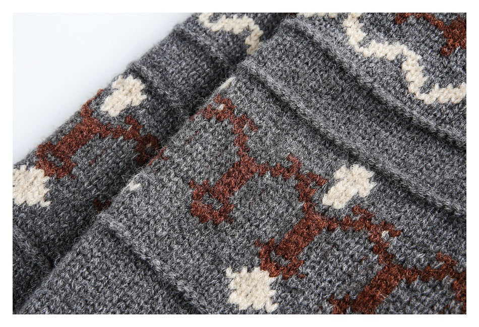 Close-up of gray knit with cream and rust geometric patterning and a raised seam.