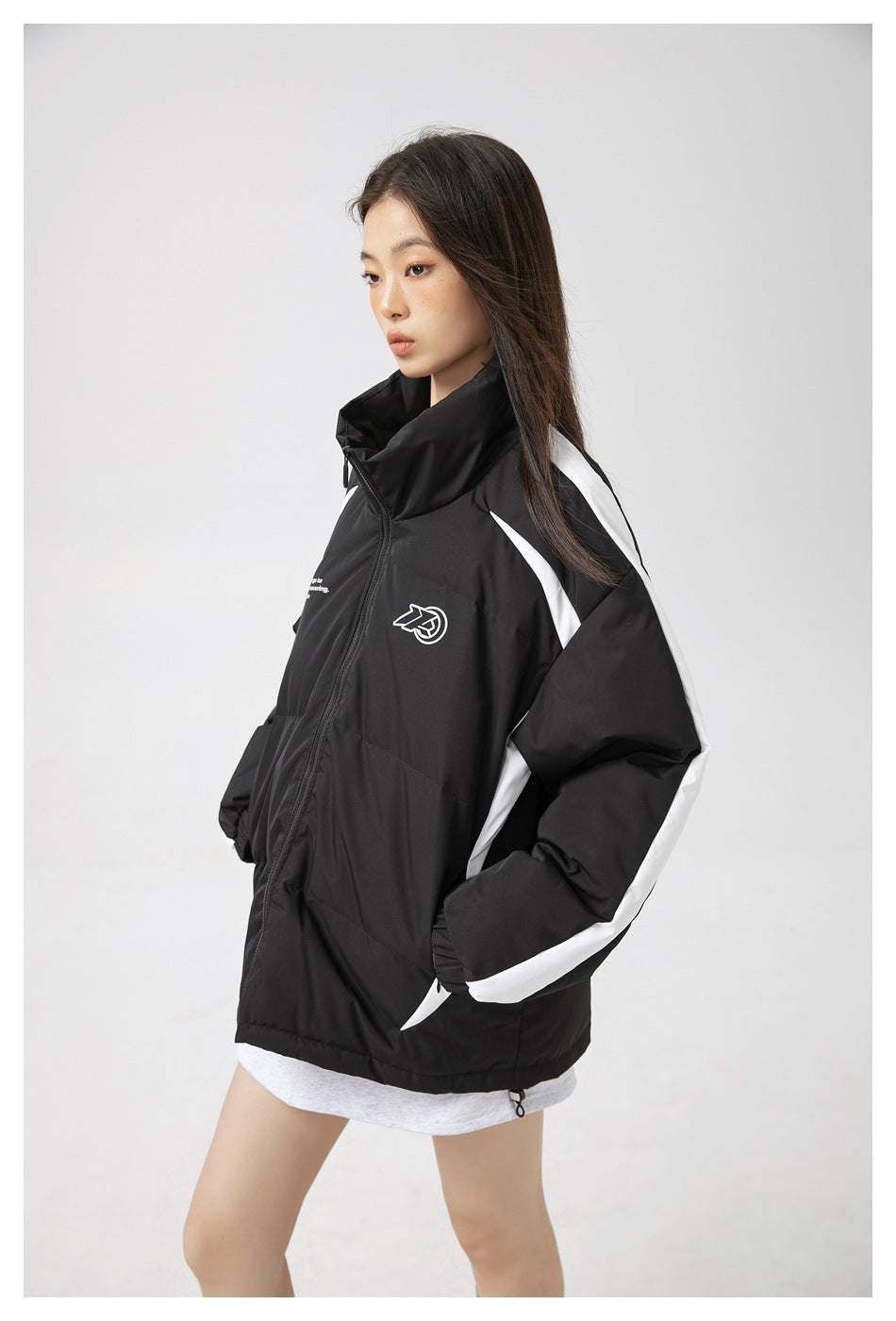 Side view of a model wearing a black padded jacket with a high collar and white stripes along the sleeves and sides.