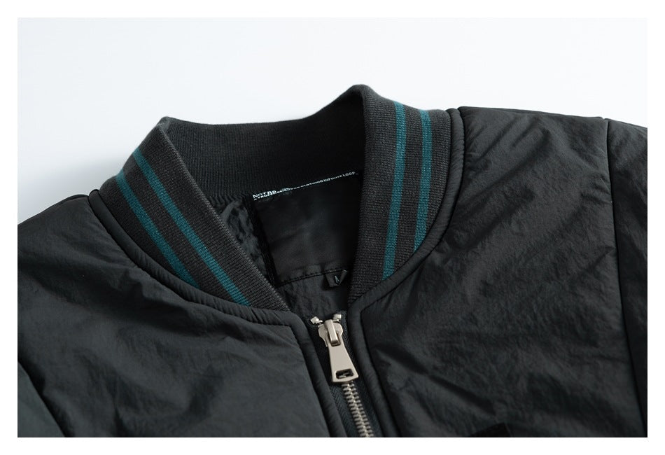 Framed close-up of a black jacket's teal-striped collar and silver front zipper.