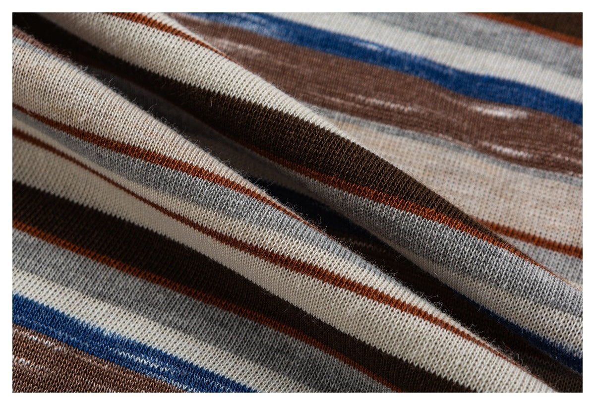 Close-up of striped knit fabric in cream, gray, brown, rust, and blue.