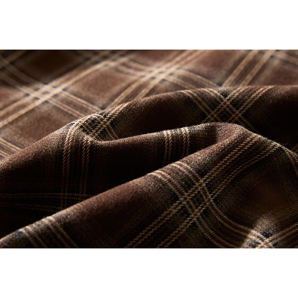 Close-up showing the brown jacket's plaid fabric and folded layers.