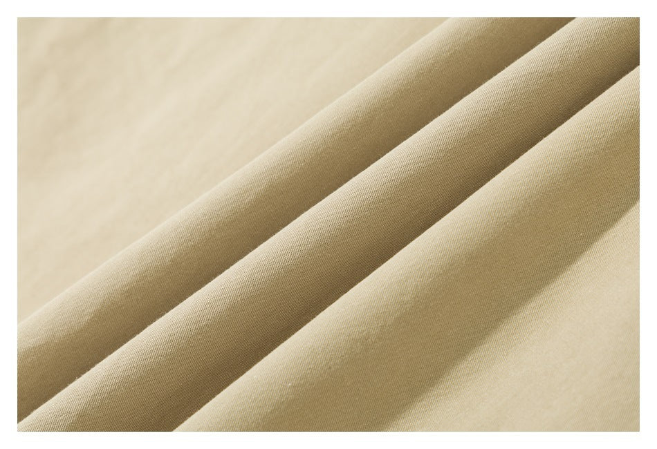 Close-up of smooth beige fabric draped in soft folds.