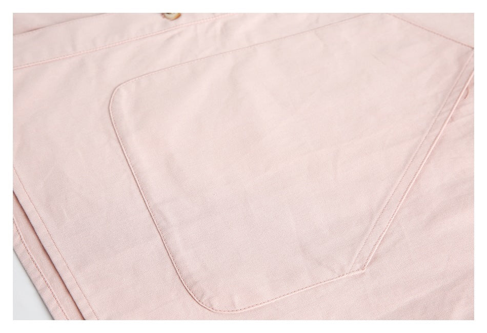 Close-up of a large, angular patch pocket on the pale pink shirt.