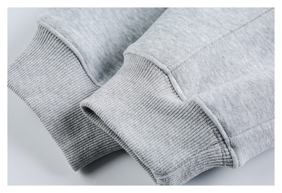 Close-up of ribbed cuffs and seams on a light gray heathered garment.