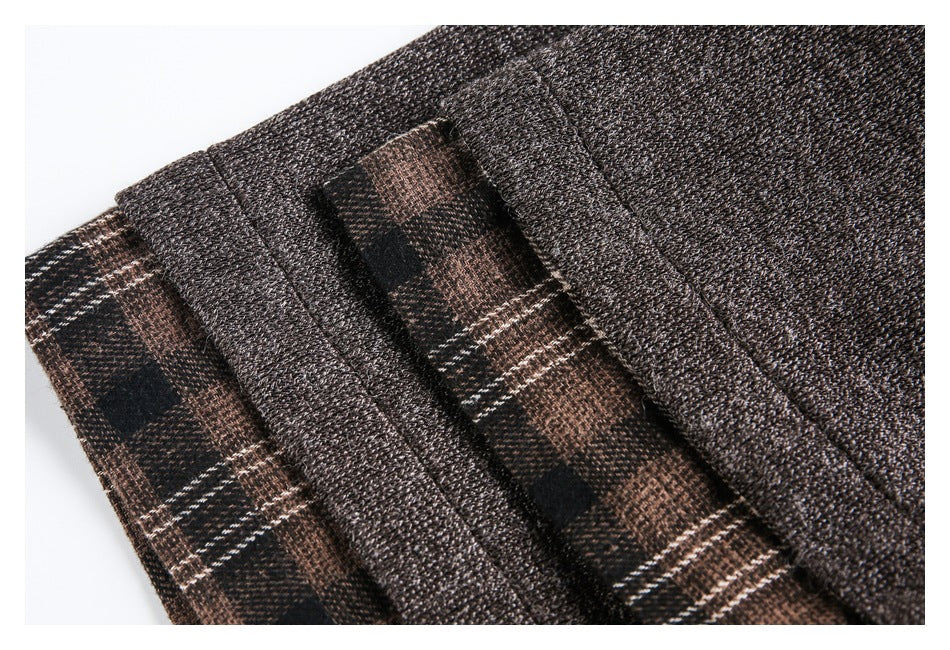 Close-up of dark brown jacket edges beside brown and black plaid fabric.