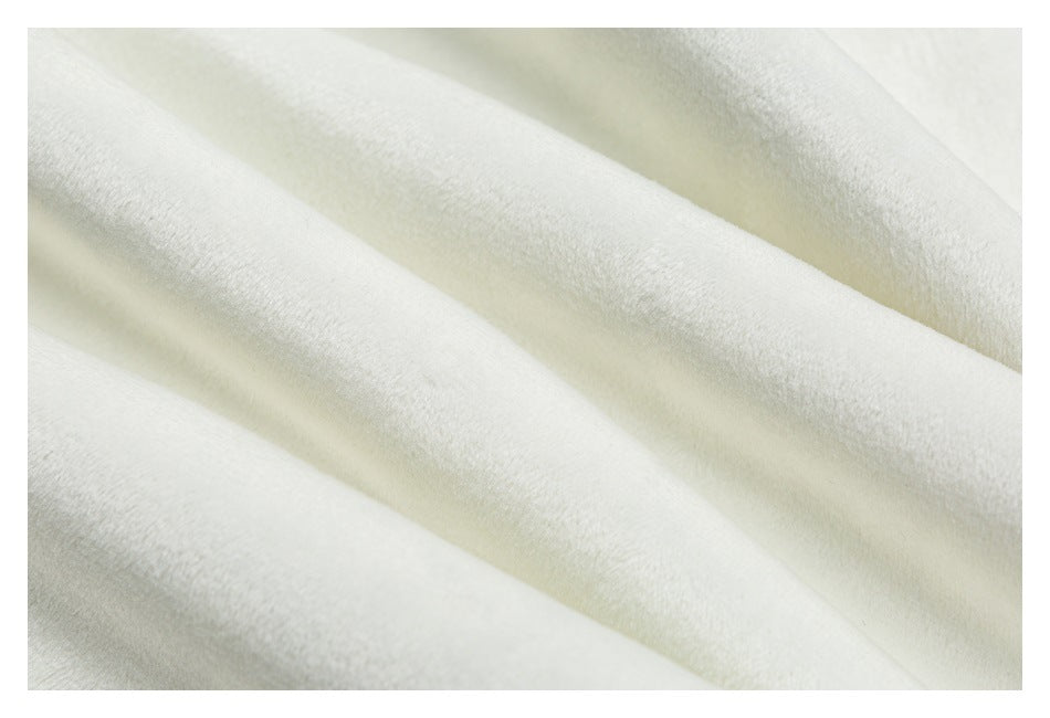 Extreme close-up of softly textured, pale gray-white garment fabric arranged in folds.