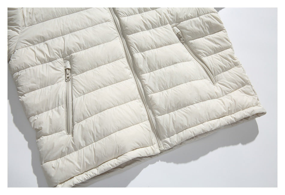 Close-up of an ivory quilted jacket front with a central zipper and two vertical zip pockets.