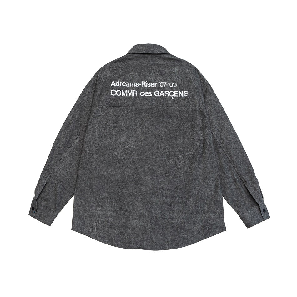 Back view of a black gray washed-look long-sleeve shirt with a white distressed text print across the upper back