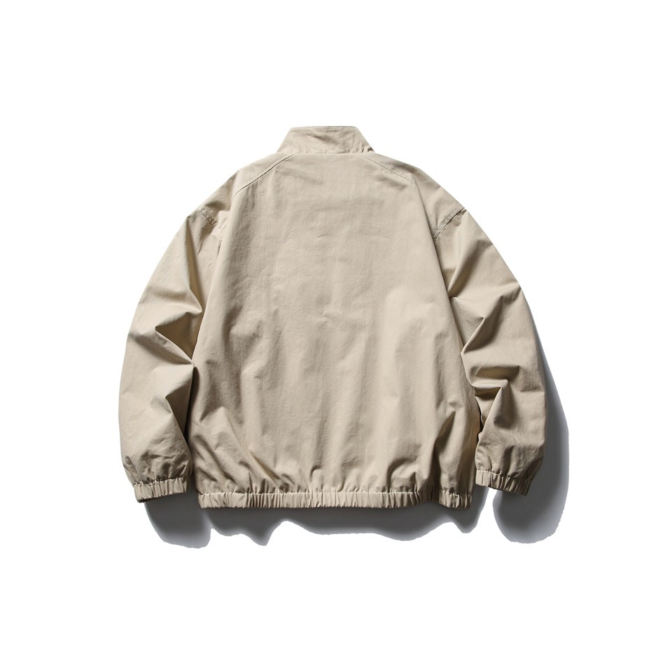 Back view of a light beige jacket with a stand collar and gathered cuffs and hem.