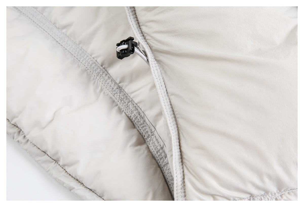 Close-up of an off-white padded jacket seam with a black cord lock and white drawcord.