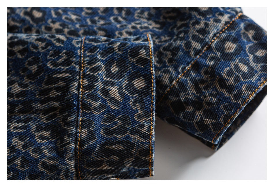 Close-up of a folded blue leopard-print denim cuff with contrasting orange topstitching.