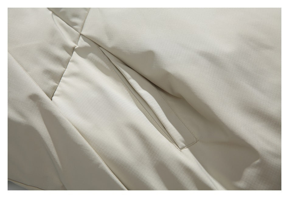 Close-up of a concealed pocket opening and panel seams on an off-white jacket.