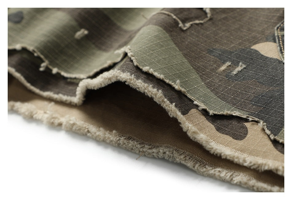 Close-up of frayed, layered hems on olive, brown, and tan camouflage shorts.