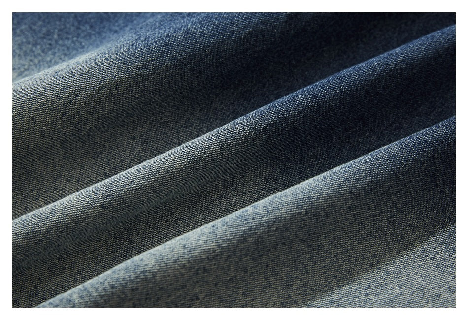 Close-up of dark blue denim fabric folded to show its washed texture.
