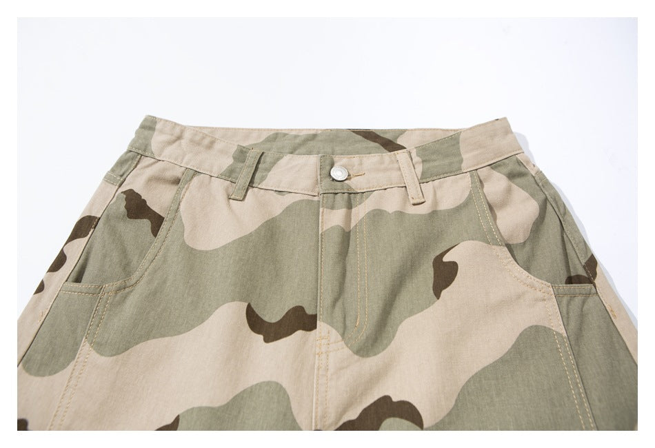 Cropped front view of the waistband, button, and pockets on beige, olive, and brown camouflage pants.